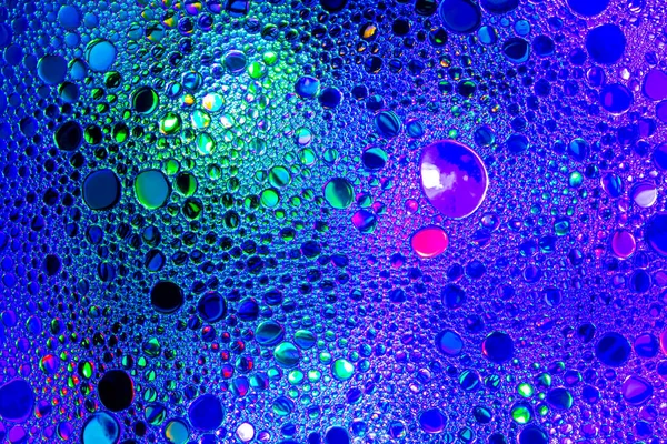 Kolorowe krople oleju na wodzie. Niebieski i fioletowy okrągły kolor — Zdjęcie stockowe