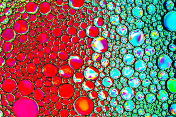 Vista superior em gotas coloridas de óleo na água. Círculos e oval — Fotografia de Stock