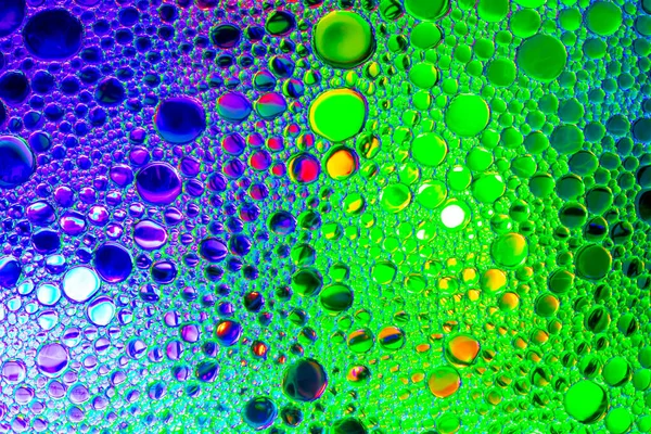 Colorful drops of oil on the water. Blue and green colored circl — Stock Photo, Image