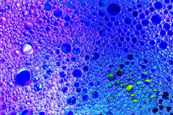Kleurrijke druppels olie op het water. Blauw en violet gekleurde cirkel — Stockfoto