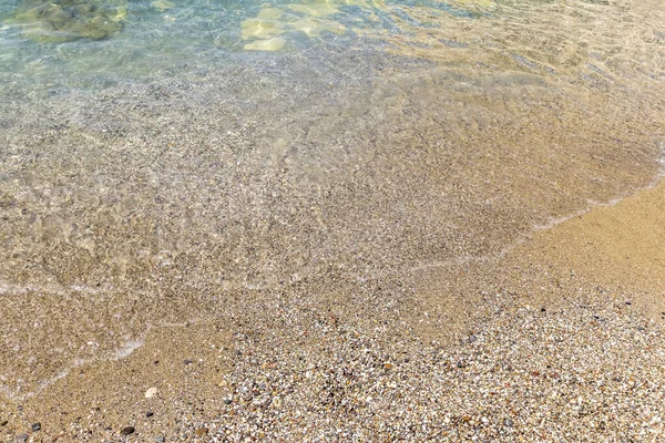 Mořský příboj na pláži se žlutým pískem a čistou vodou. — Stock fotografie