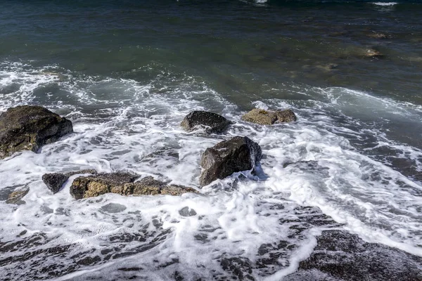 Surfe no mar na praia com areia vulcânica preta e pedras . — Fotografia de Stock