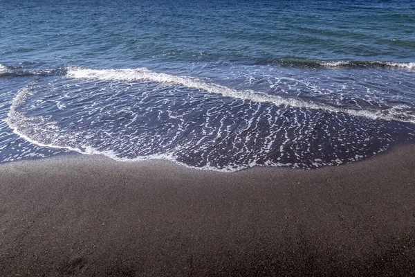 Sea surf on the beach with black volkanic sand. — Stock Photo, Image