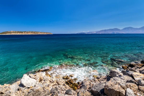 Agios Nikolaos coastline on a sunny day with clear sea and cliffs. — Stock Photo, Image