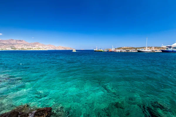 Agios Nikolaos coastline on a sunny day with clear sea and cliffs. — Stock Photo, Image