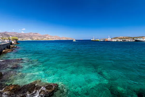 Agios Nikolaos coastline on a sunny day with clear sea and cliffs. — Stock Photo, Image