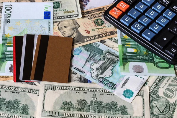 Dólar, rublo y euro bils, tarjeta de crédito y calculadora negro . — Foto de Stock