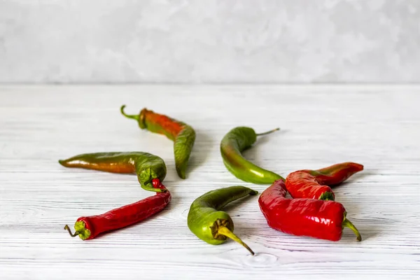 Red and green chili pepper on a white wooden vintage background.