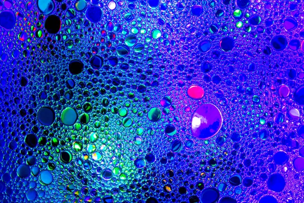 Kolorowe krople oleju na wodzie. Niebieski i fioletowy okrągły — Zdjęcie stockowe