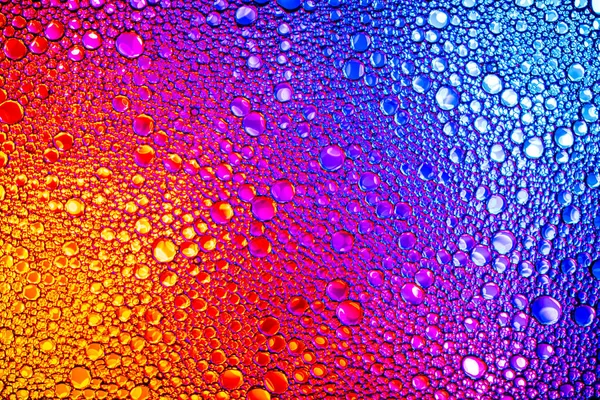 위에서 내려다보면 물 위에 있는 다채 로운 기름 방울이 보인다. 무지개 혹은 광선 — 스톡 사진