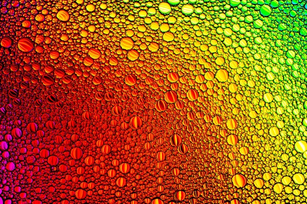 Top view on a colorful drops of oil on the water. Rainbow or spe — Stock Photo, Image