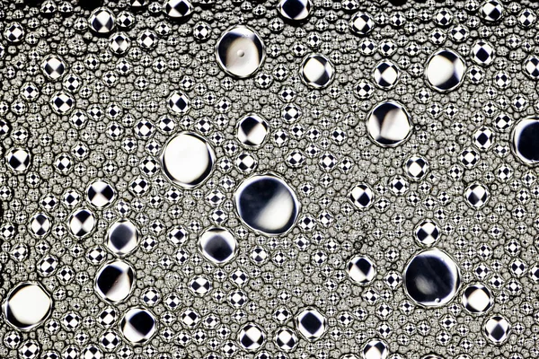 Zwart-witte druppels olie op het water. Cirkels en ovalen. Ab — Stockfoto