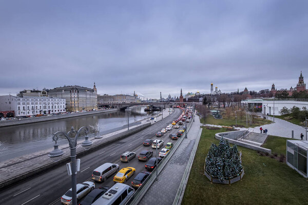 MOSCOW, RUSSIA - DECEMBER 11, 2019: Traffic jam on a Moscow river embankment,Moscow Kremlin and Red Square on a cloudy winter overcast day. Dirty cars.