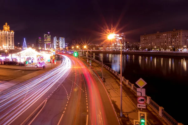 Déplacement de voiture avec une lumière floue à travers la ville la nuit près de Moscou riv — Photo