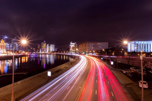 Automóvil en movimiento con luz borrosa a través de la ciudad por la noche cerca de Moscú riv — Foto de Stock