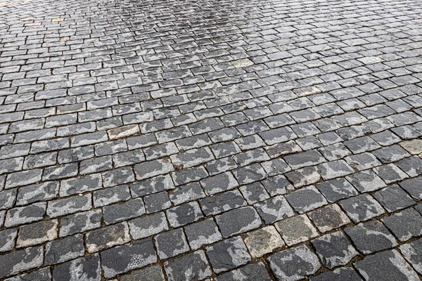 Vista superior sobre pavimentação estrada de pedra molhada após a chuva. Velho pavimento de gr — Fotografia de Stock