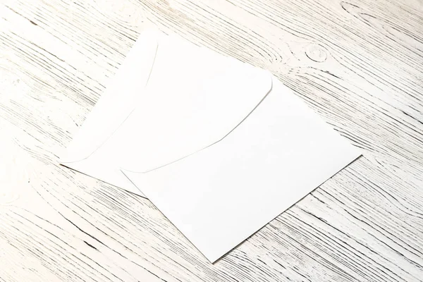 Dois envelopes postais brancos numa mesa de madeira. Fundo abstrato — Fotografia de Stock