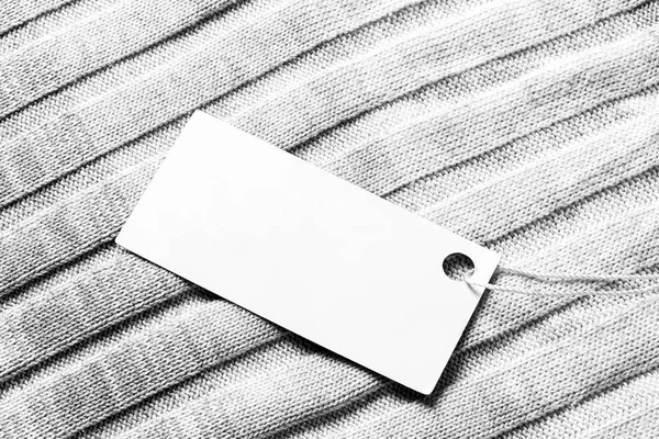 Wit etiket op een wollen stof. Abstracte achtergrond voor ontwerp. — Stockfoto