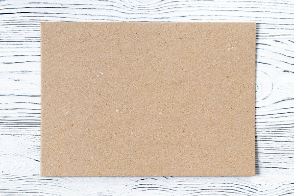 Картон на белом деревянном столе. Абстрактный фон для дебюта — стоковое фото