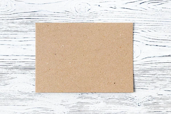 Cartão sobre uma mesa de madeira branca. Fundo abstrato para desig — Fotografia de Stock