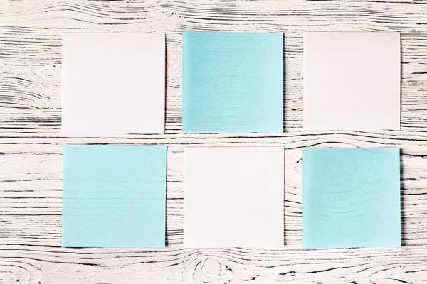 Hojas de papel blanco y azul sobre una mesa de madera. Fondo abstracto —  Fotos de Stock