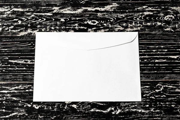 White postal envelope on a black wooden table. Abstract backgrou