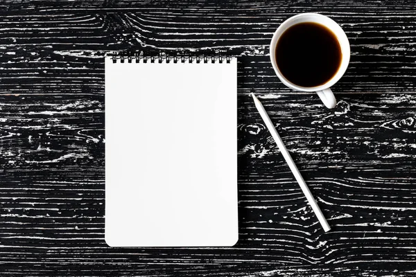 Caderno, lápis e xícara de café em uma mesa de madeira preta. Abdominais — Fotografia de Stock