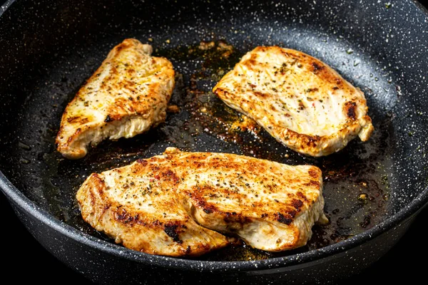 Turkey steak grilled in a pan. The cooking process.