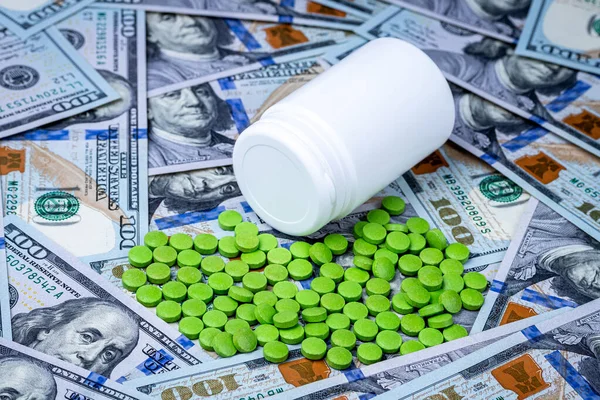 Зеленые Таблетки Фоне Стодолларовых Купюр Понятие Дороговизны Здравоохранения Финансирования Медицины — стоковое фото