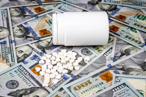 100美元钞票背景下的心形药丸 昂贵的医疗或医疗融资成本的概念 白色药瓶 有文字复制空间 — 图库照片