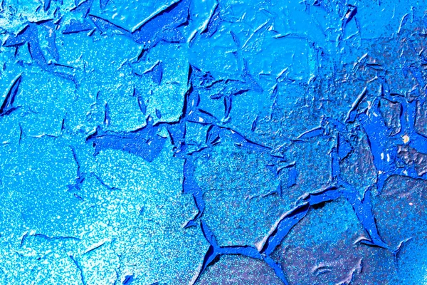 Fragment of colorful graffiti painted on a concrete wall. Bright  blue abstract background for design with peeling paint and scratches.