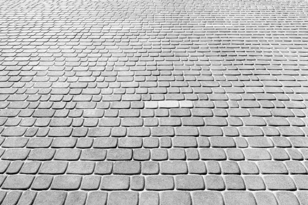 Top view on gray paving stone road. Old pavement of granite texture. Street cobblestone sidewalk. Abstract backdrop for design.