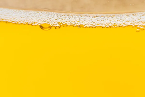 Texture of foam and bubbles in light beer. Abstract backdrop for design.
