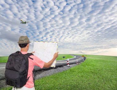 Sırt çantası ve ayakta ve yol haritası seyir şapka ile erkek turist