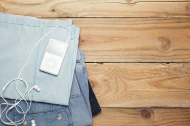 Ahşap arka plan üzerinde kulaklık ile kumaş ve müzik çalar