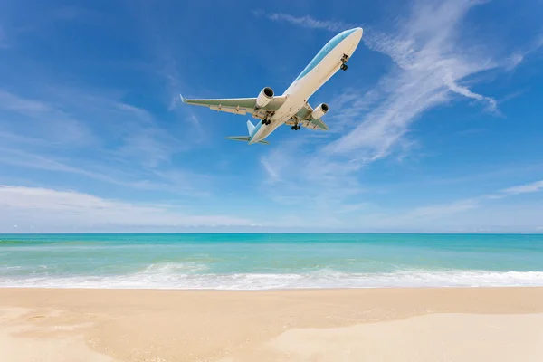 Airplane landing above beautiful beach and sea background. — Stock Photo, Image