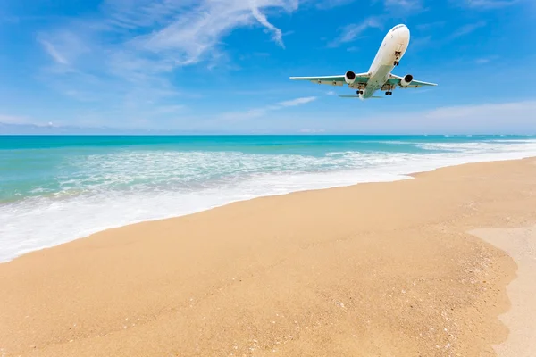 Airplane landing above beautiful beach and sea background. — Stock Photo, Image