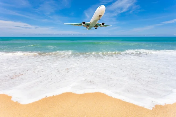 Airplane landing above beautiful beach and sea background. — Stock Photo, Image