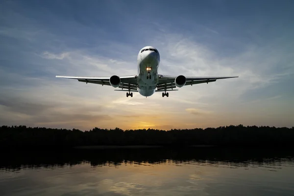 Vliegtuig vliegen in de lucht tropische zee op zonsondergang tijd. — Stockfoto