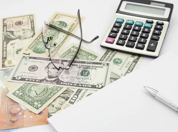 White office desk table with pen calculator glasses and banknote — Stock Photo, Image