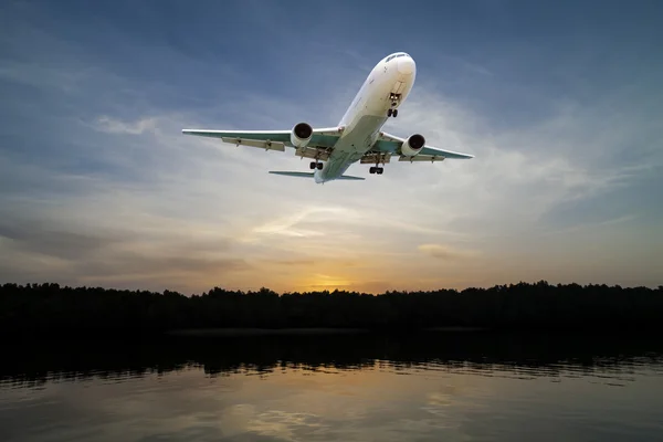 Vliegtuig vliegen in de lucht tropische zee op zonsondergang tijd. — Stockfoto