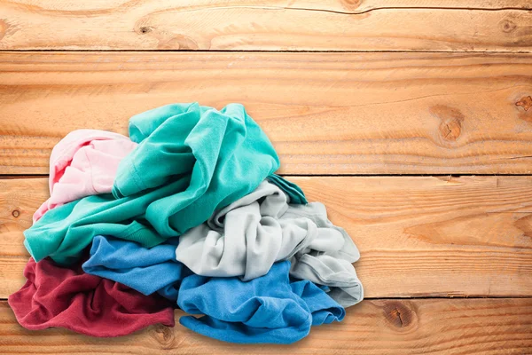 Pilha de roupas coloridas sujas no chão de madeira  . — Fotografia de Stock