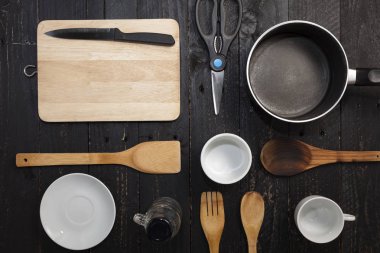 siyah ahşap zemin üzerine mutfak eşyaları.