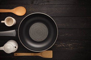 Boş Pan ve Spatula üst görünümü siyah ahşap zemin üzerine.