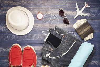 Kıyafet ve aksesuarları seyahat mavi ahşap zemin üzerine