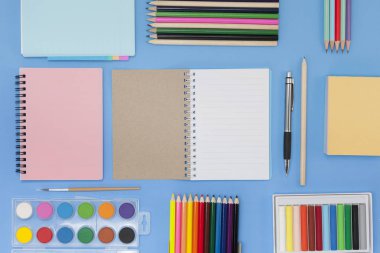 Geri okul kavramı için mavi arka plan üzerinde okul malzemeleri.