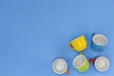 mavi arka plan üzerinde renkli kahve bardağı.