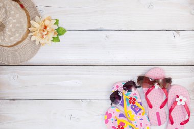 Beyaz ahşap zemin üzerinde güneş gözlüğü ile plaj ayakkabı,
