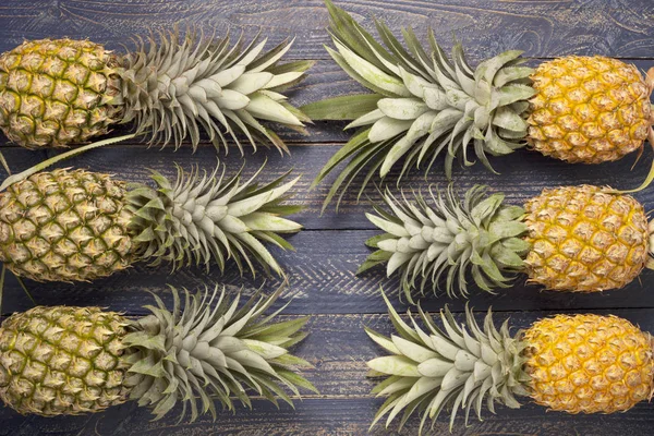 Rangée d'ananas sur fond de table en bois bleu . — Photo