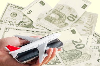 Elini tut uçak model cep telefonu banknotların arka plan üzerinde